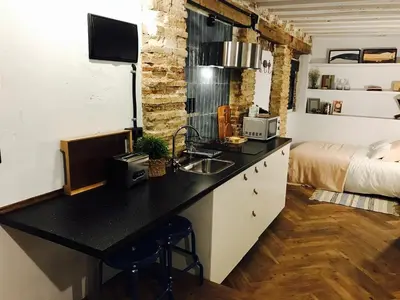 a kitchen with a sink and a bed in a room at Ático Falla in Cádiz