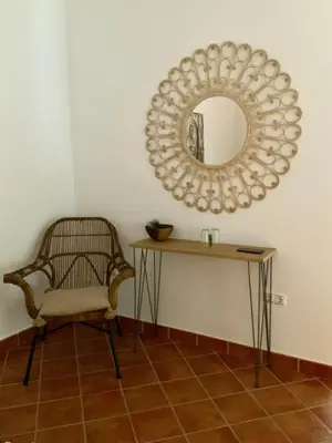 a mirror on a wall with a chair and a table at Cortijo Bablou in Arcos de la Frontera
