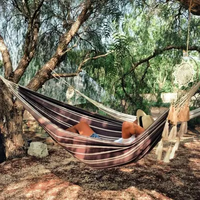 a person laying in a hammock under a tree at Cortijo Bablou in Arcos de la Frontera