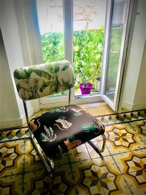a chair in a room with a table and a window at Apartamentos La Selva in Cádiz