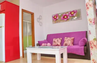 a living room with a purple couch and a table at Casa Independiente Conil in Conil de la Frontera