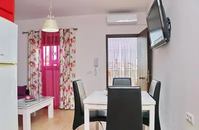 a dining room with a table and a tv on the wall at Casa Independiente Conil in Conil de la Frontera