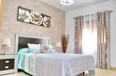 a bedroom with a bed and a painting on the wall at Casa Independiente Conil in Conil de la Frontera