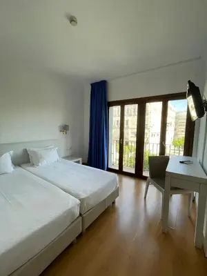 a bedroom with a bed and a table and a window at Hotel Trafalgar in Jerez de la Frontera