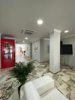 a living room with a white couch and a red door at Hotel Trafalgar in Jerez de la Frontera