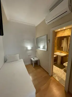a bedroom with a bed and a bathroom with a sink at Hotel Trafalgar in Jerez de la Frontera