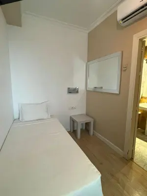 a bedroom with a white bed and a table at Hotel Trafalgar in Jerez de la Frontera