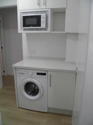 a kitchen with a washing machine and a microwave at Apartamento Playa100m in Sanlúcar de Barrameda