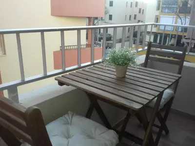 a wooden table with a potted plant on a balcony at Apartamento Playa100m in Sanlúcar de Barrameda