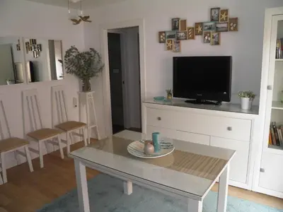 a living room with a table and a tv at Apartamento Playa100m in Sanlúcar de Barrameda