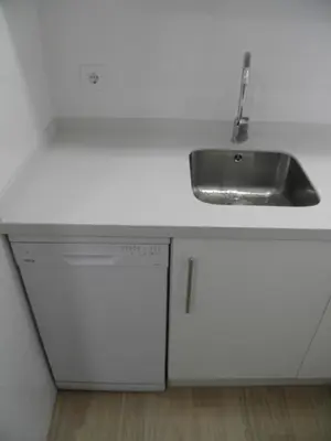 a white kitchen with a sink and a dishwasher at Apartamento Playa100m in Sanlúcar de Barrameda