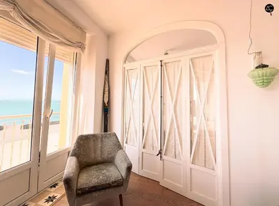 a room with a chair and a large window at Balcón al Mar con Ascensor Grupo AC Gestion in Cádiz