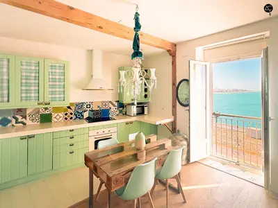 a kitchen with a table and a view of the ocean at Balcón al Mar con Ascensor Grupo AC Gestion in Cádiz