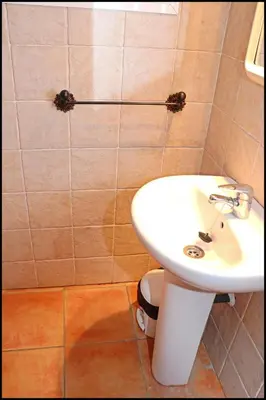 a bathroom with a white sink and a toilet at Bungalow en complejo I in Conil de la Frontera