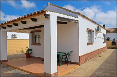 a patio with a table and a house at Bungalow complejo III in Conil de la Frontera