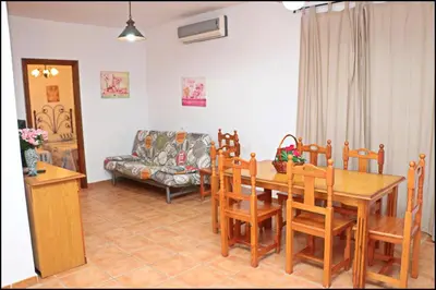 a living room with a table and chairs and a couch at Bungalow complejo III in Conil de la Frontera