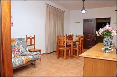 a kitchen and living room with a table and chairs at Bungalow complejo III in Conil de la Frontera