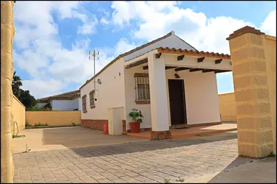 a small white house with a large driveway at Bungalow complejo III in Conil de la Frontera