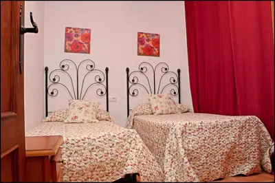 a bedroom with two beds and a red curtain at Bungalow en complejo II in Conil de la Frontera