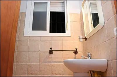a bathroom with a sink and a window at Bungalow en complejo II in Conil de la Frontera