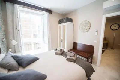 a bedroom with a large bed and a large window at Sagasta 13 in Cádiz