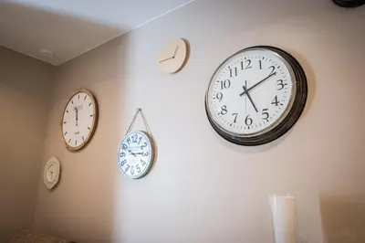 four clocks are hanging on a wall at Sagasta 13 in Cádiz
