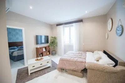 a bedroom with a bed and a couch and a tv at Sagasta 13 in Cádiz