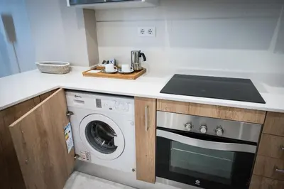 a kitchen with a stove and a washing machine at Sagasta 13 in Cádiz