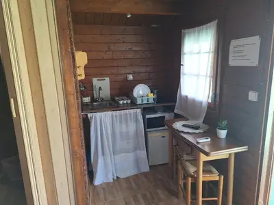 a small kitchen in a log cabin with a table at Los Duendes in El Puerto de Santa María