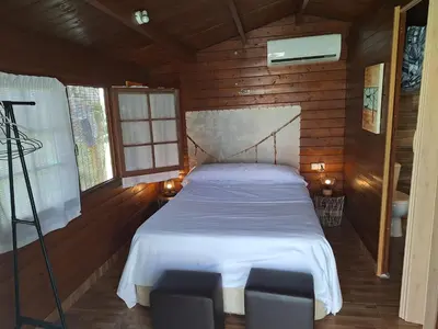 a bedroom with a bed with two chairs in it at Los Duendes in El Puerto de Santa María
