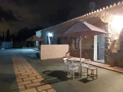 a table and chairs with an umbrella on a patio at night at Los Duendes in El Puerto de Santa María