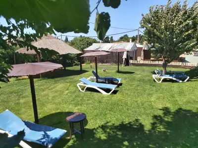 a group of lawn chairs and umbrellas in a yard at Los Duendes in El Puerto de Santa María