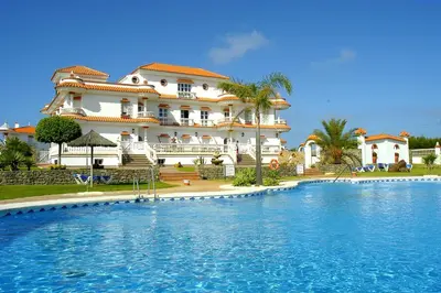a large house with a swimming pool in front of it at Hotel y Apartamentos Diufain in Conil de la Frontera