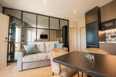 a living room with a couch and a table and chairs at Hotel y Apartamentos Diufain in Conil de la Frontera