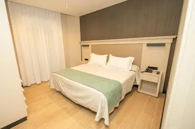 a bedroom with a large bed with white pillows at Hotel y Apartamentos Diufain in Conil de la Frontera