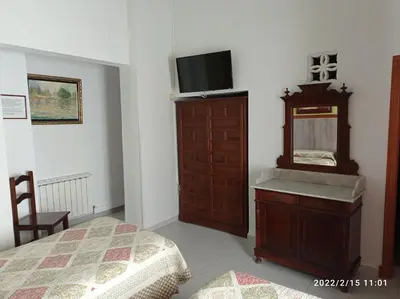 a bedroom with a bed and a dresser with a mirror at Hostal Manolo in El Puerto de Santa María