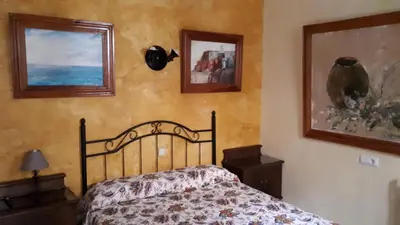 a bedroom with a bed and two pictures on the wall at Hostal Manolo in El Puerto de Santa María