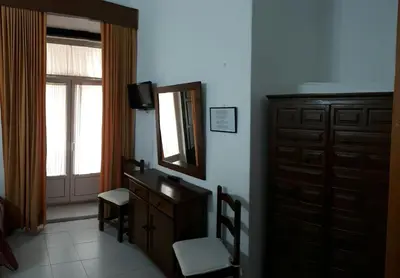 a bedroom with a dresser and a mirror at Hostal Manolo in El Puerto de Santa María