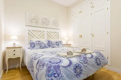 a bedroom with a blue and white bed with towels on it at El Patio in Cádiz
