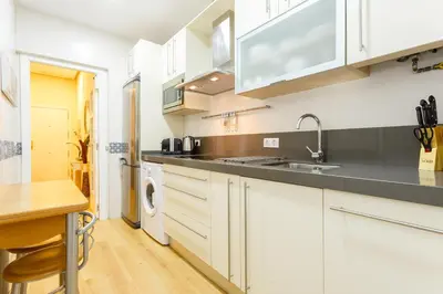 a kitchen with white cabinets and a sink at El Patio in Cádiz