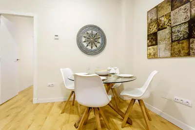 a dining room with a table and white chairs at El Patio in Cádiz
