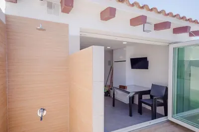 a room with a wooden wall with a table and a window at Real de La Barrosa 46 in Chiclana de la Frontera