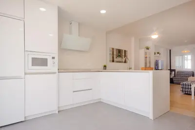 a kitchen with white cabinets and a microwave at Real de La Barrosa 46 in Chiclana de la Frontera