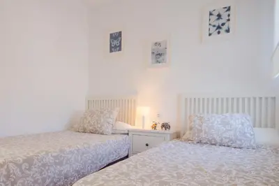two beds sitting next to each other in a bedroom at Real de La Barrosa 46 in Chiclana de la Frontera