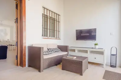 a living room with a couch and a tv at Real de La Barrosa 46 in Chiclana de la Frontera