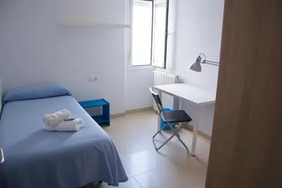 a bedroom with a bed and a desk and a chair at Residencia Universitaria Cadiz Centro in Cádiz