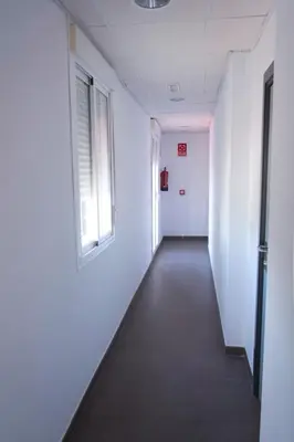 an empty hallway in an office building with a window at Residencia Universitaria Cadiz Centro in Cádiz