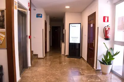 a hallway of a hospital with a fire extinguisher on the wall at Residencia Universitaria Cadiz Centro in Cádiz