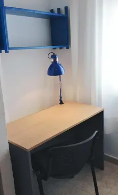 a desk with a blue lamp on top of it at Residencia Universitaria Cadiz Centro in Cádiz