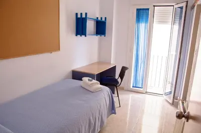 a bedroom with a bed and a desk and a chair at Residencia Universitaria Cadiz Centro in Cádiz
